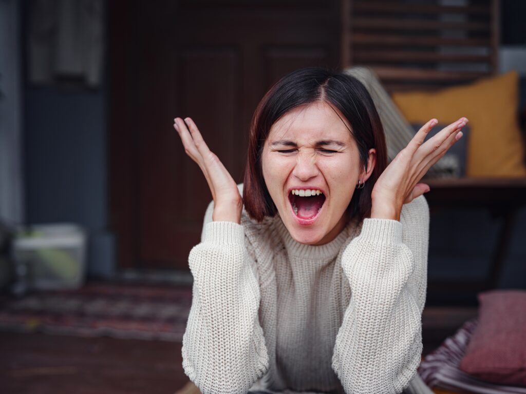 Young depressed asian woman sitting on porch of backyard.